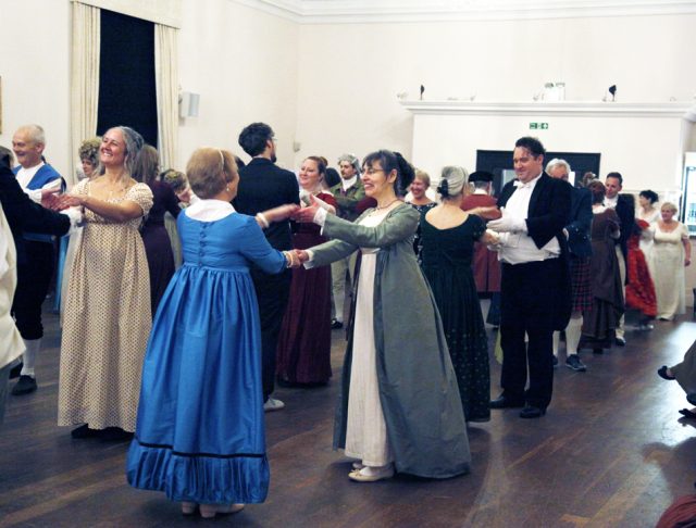 Taking crossed hands during a longways Playford Dance at the Norwich Assembly Ball, 2025 at theNorwich Assembly House.