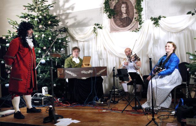 The players for NHD's Norwich Assembly Ball gather on the stage below the picture of John Playford.